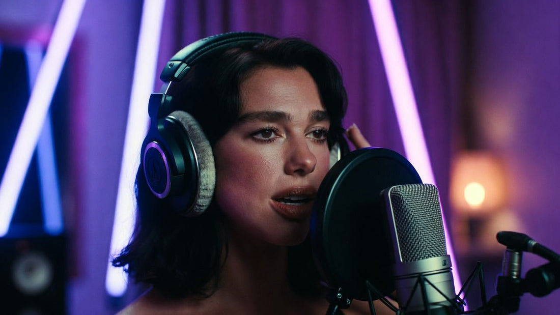 Artist recording confident pop vocals over a Dua Lipa–inspired retro pop type beat in a modern studio